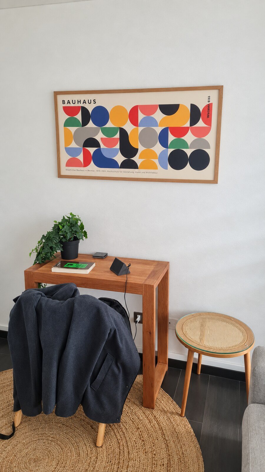Escritorio de madera, sillón y lámina Bauhaus en el consultorio